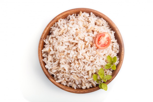 Unpolished rice porridge in wooden bowl isolated on white background. Top view.