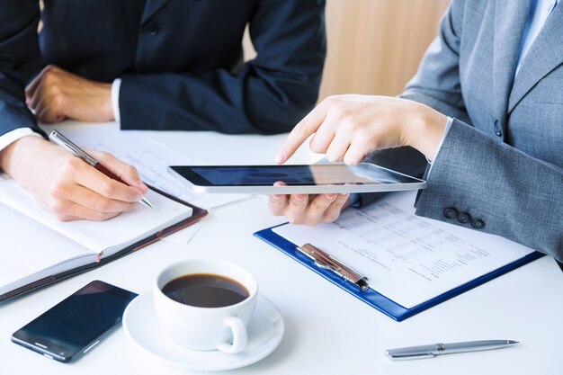 Unrecognizable business colleagues working together and using a digital tablet