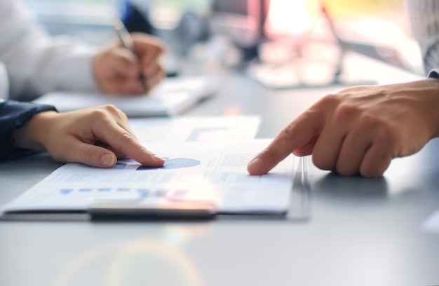 Unrecognizable business person analyzing graphs and taking notes