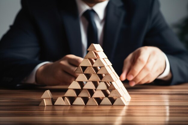 Unrecognizable businessman forming a wooden pyramid closeup shot