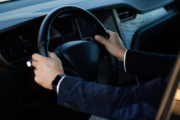 Unrecognizable businessman putting his hands on steering wheel of car close up of man hand on car