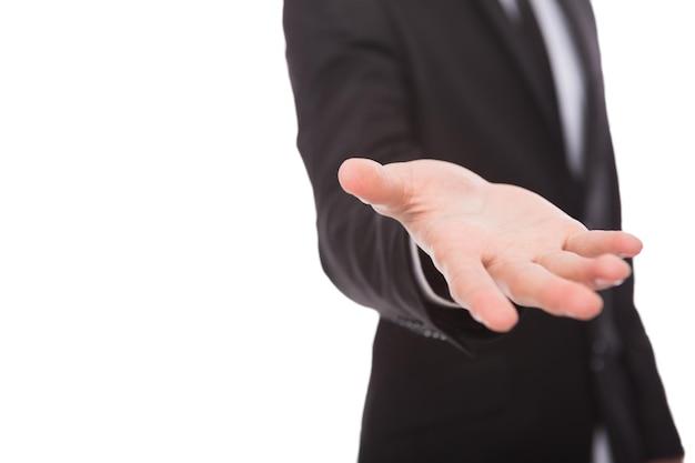 Unrecognizable businessman welcoming you isolated on white. Cropped image man in suit opening palm in inviting gesture