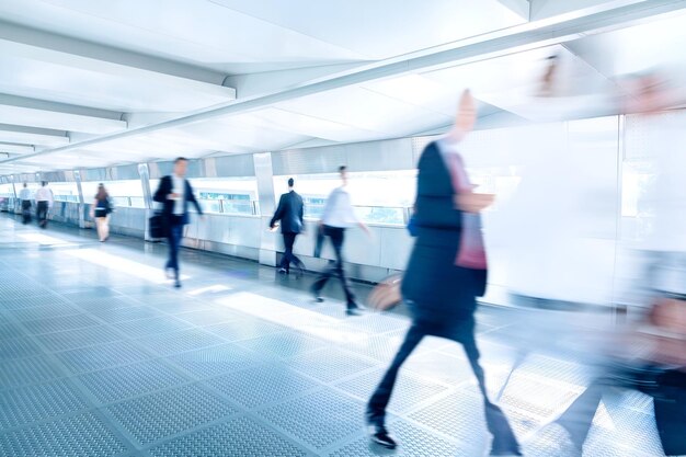 Unrecognizable businessmen walking at footbridge corridor blurred motion