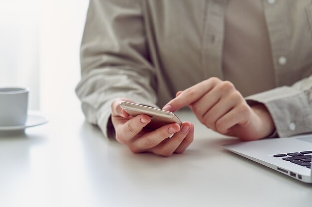 Unrecognizable female doomscrolling smartphone at work concept of millennial information hygiene