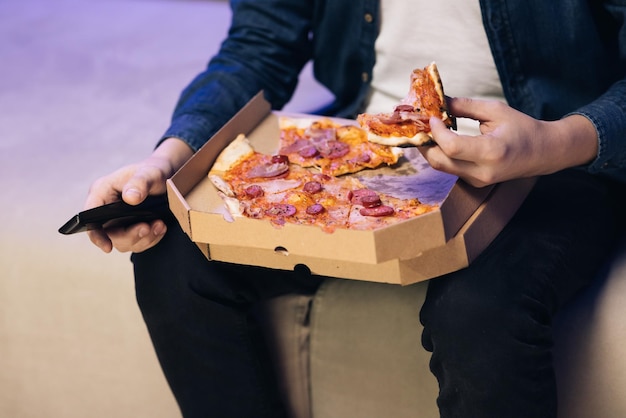 Unrecognizable hand opening delivery box with hot delicious pizza inside food delivery service