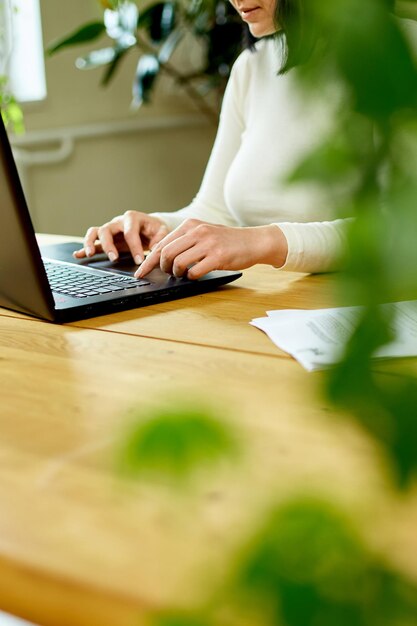 Unrecognizable hand Woman using search a laptop at home