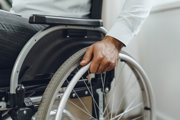 Unrecognizable man sitting in wheelchair close up photo