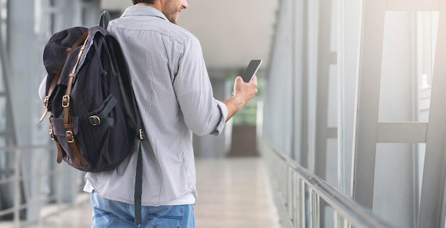 Unrecognizable Man Walking In Airport Terminal And Using Smartphone Browsing Internet