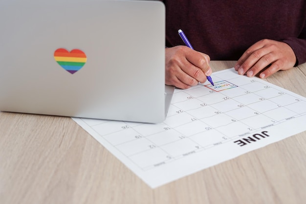 Unrecognizable mature man marking on a calendar the date of the International LGBTQ Pride Day