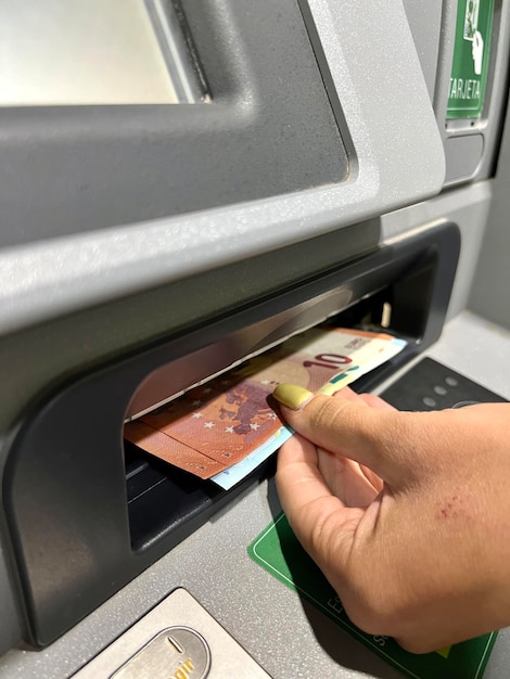 Unrecognizable people withdrawing money from an ATM Electronic money withdrawal concept