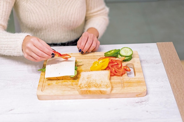 Unrecognizable person cooking a vegetable sandwich in the kitchen at home Placing the red pepper