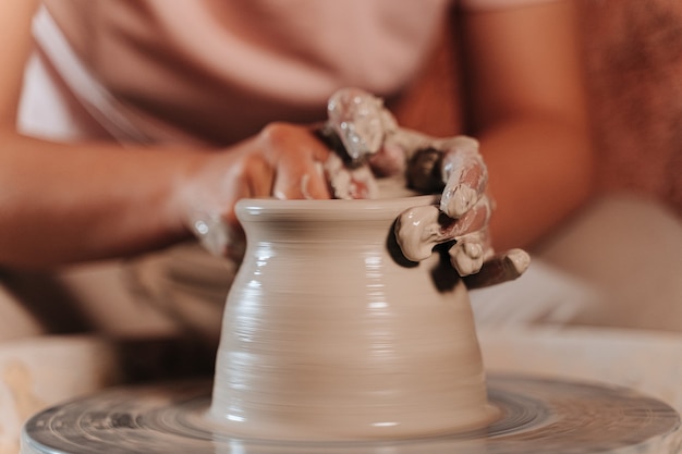 Unrecognizable person shaping a material called terracotta