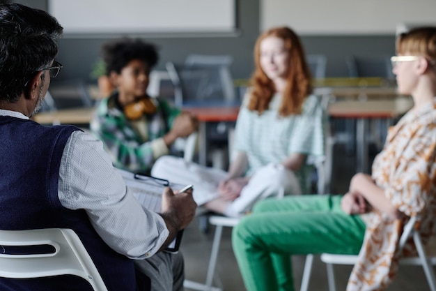 Unrecognizable psychologist working with teenagers