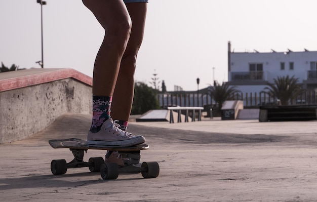 Unrecognizable skater woman legs close up at the skate park