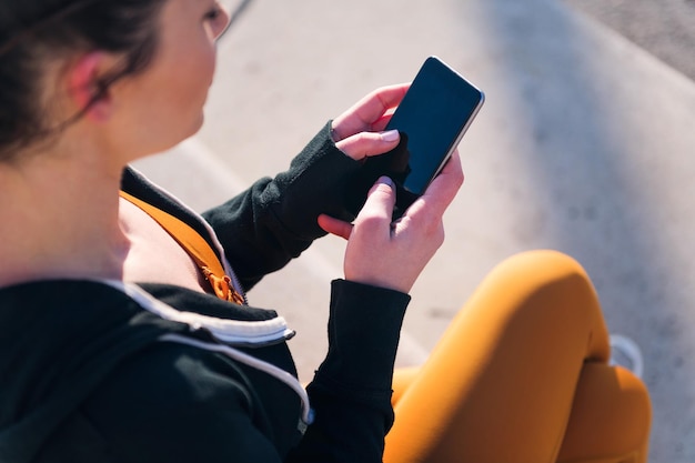 Unrecognizable sportive woman using a mobile phone