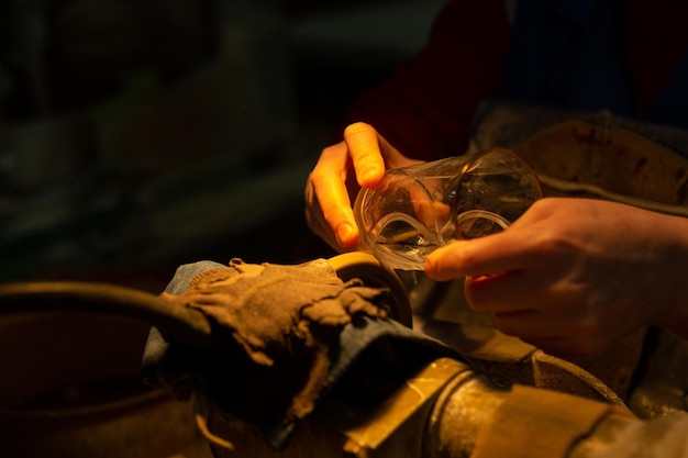 Unrecognizable woman decorating glass in manufacture with diamond circle