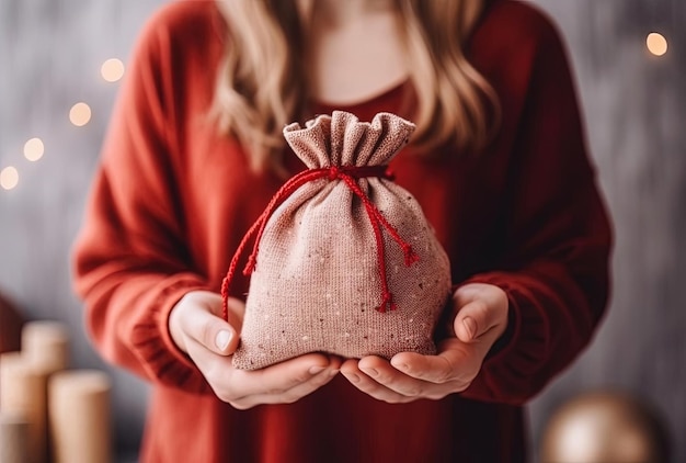 Unrecognizable woman holding Christmas gift in cloth bag