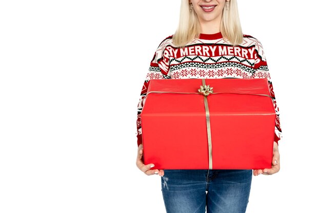 Unrecognizable woman holding Christmas present Unrecognizable woman promoting sales with a gift dressed in a Christmas sweater and wearing a Santa Claus hat Studio background white