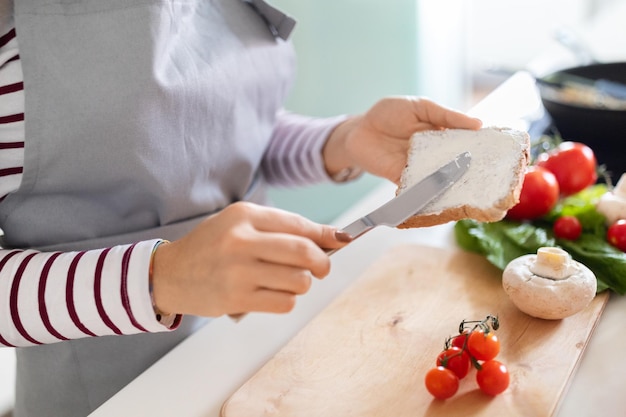 Unrecognizable woman making healthy dinner preparing meal at home cropped