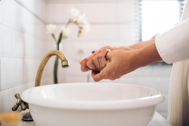 Unrecognizable woman washing her hands with soap in a vintage bathroom