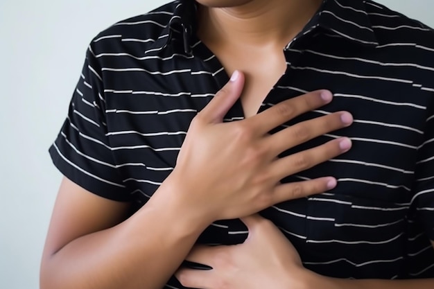 unrecognizable Young Asian man grabbing or holding his chest area