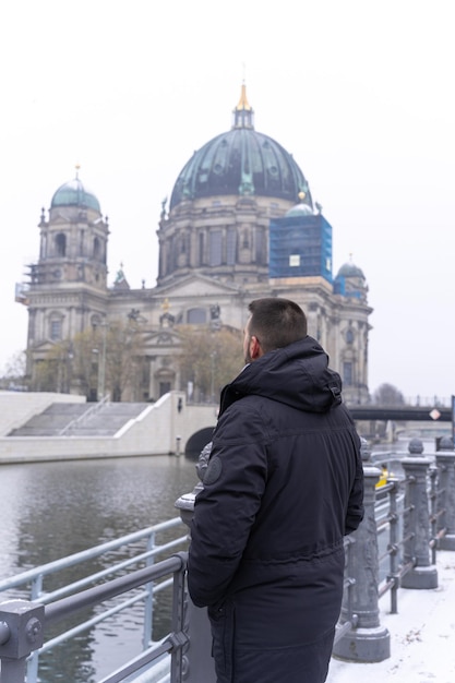 Unrecognizable young male tourist and in the background the Berlin Cathedral Germany