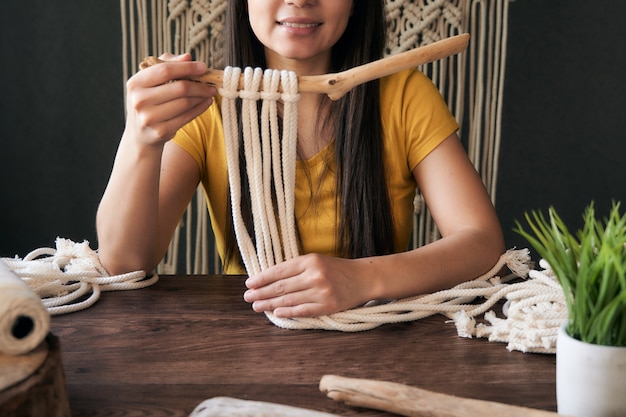 Unrecognizable young woman holding a macrame decoration