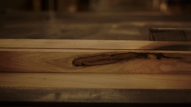 Unrecognized guy working with saw machine in carpentry workshop Closeup man preparing plank for product in studio Unknown handyman cutting plank indoors