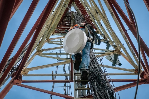 Unrecognized technician climbing up a telecommunication tower