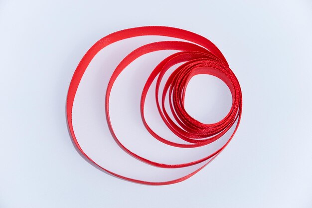 Photo an unrolled roll of red ribbon isolated on a white background