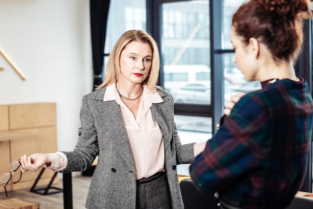 Unsatisfied with work. Stylish appealing businesswoman feeling unsatisfied with work of trainee