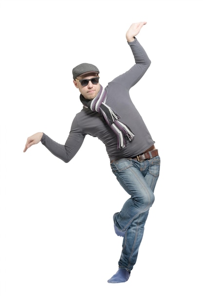 Unshaven bald man wearing a cap jeans sunglasses and a scarf dancing a strange dance Isolated