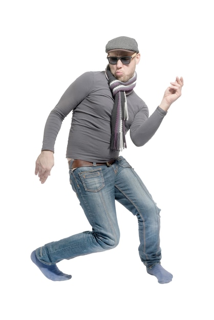 Unshaven bald man wearing a cap jeans sunglasses and a scarf dancing a strange dance Isolated