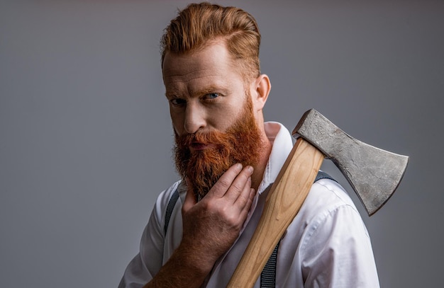 Unshaven masculine man with axe isolated on grey masculine man with axe in studio