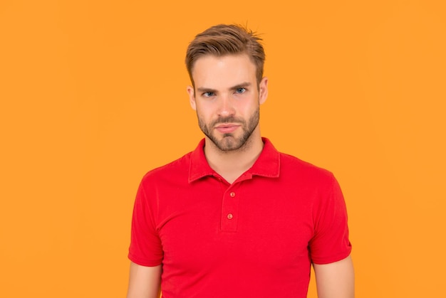 unshaven young man in red shirt on yellow background fashion