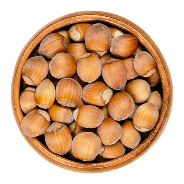 Unshelled natural hazelnuts in wooden bowl