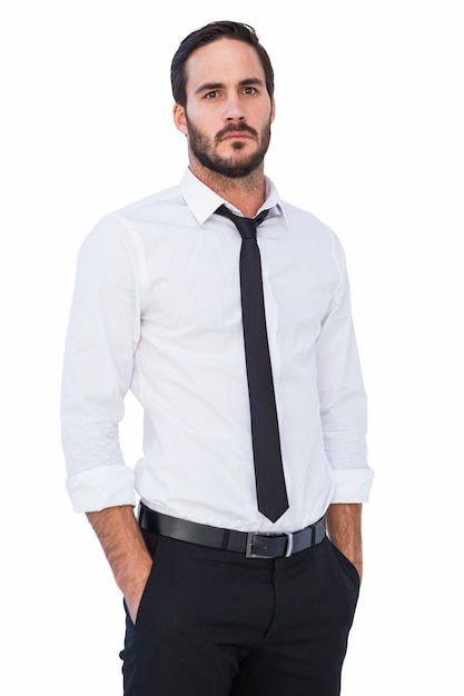 Unsmiling businessman standing with hands in pockets