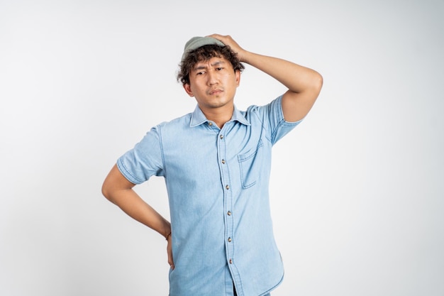 Unsure asian young man thinking on isolated background