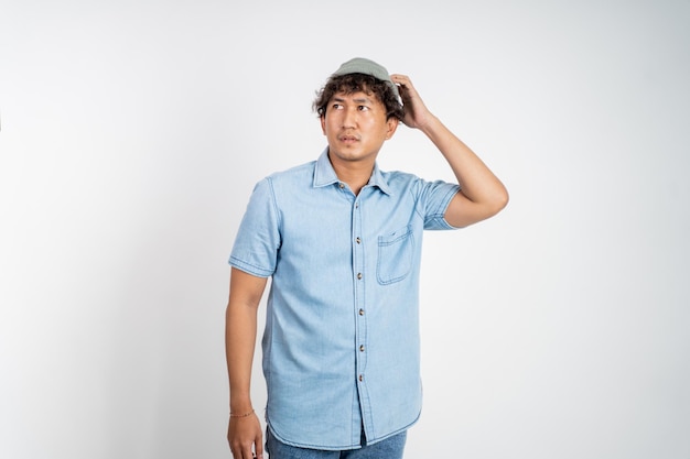 Unsure asian young man thinking on isolated background