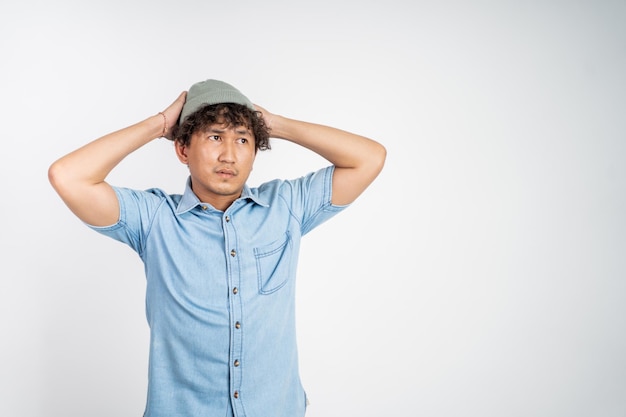 Unsure asian young man thinking on isolated background