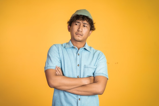 Unsure asian young man thinking on isolated background