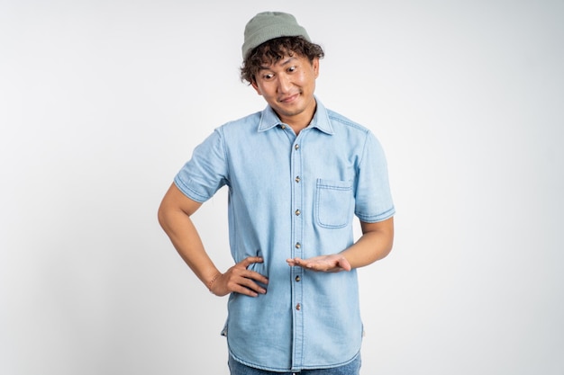 Unsure asian young man with arms crossed on isolated