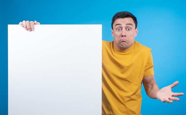 Unsure man shrugging shoulders and showing blank banner