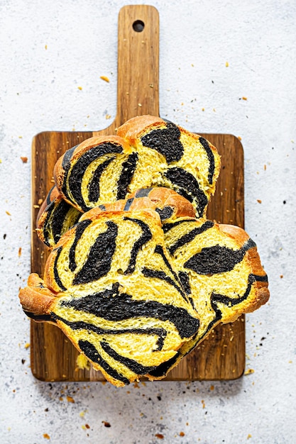 Unusual pumpkin marbled tiger print bread with cuttlefish ink braided on a wooden board on a ligh