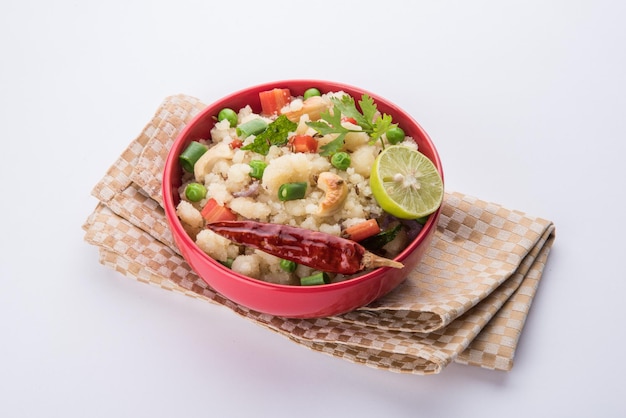 Upma or Uppittu is a popular breakfast dish in South India and Maharashtra. Semolina or Rava or coarse rice flour is main ingredients. Served in a bowl over colourful or wooden background