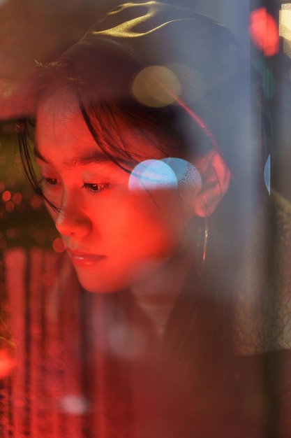 Upset asian girl suffer from solitude alone draw on wet glass in rain after breakup with boyfriend