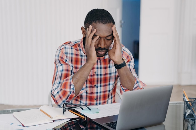 Upset black employee blames self for work mistake Frustrated guy holds head feels sad about dismissal Stress burnout