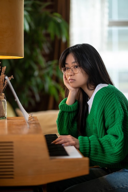 Upset and bored Longhaired asian girl sitting with unhappy look