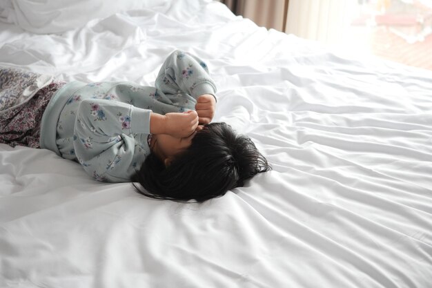 A upset child girl cover her face with hand