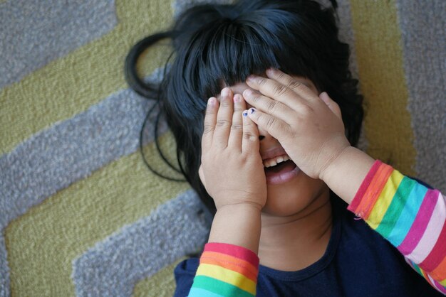 A upset child girl cover her face with hand